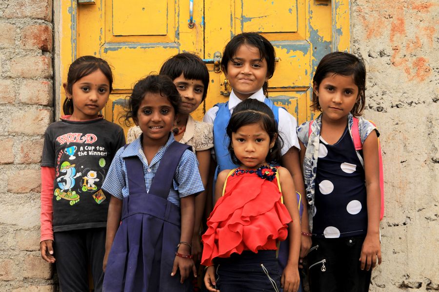 A group of girls standing together in front of a painted door