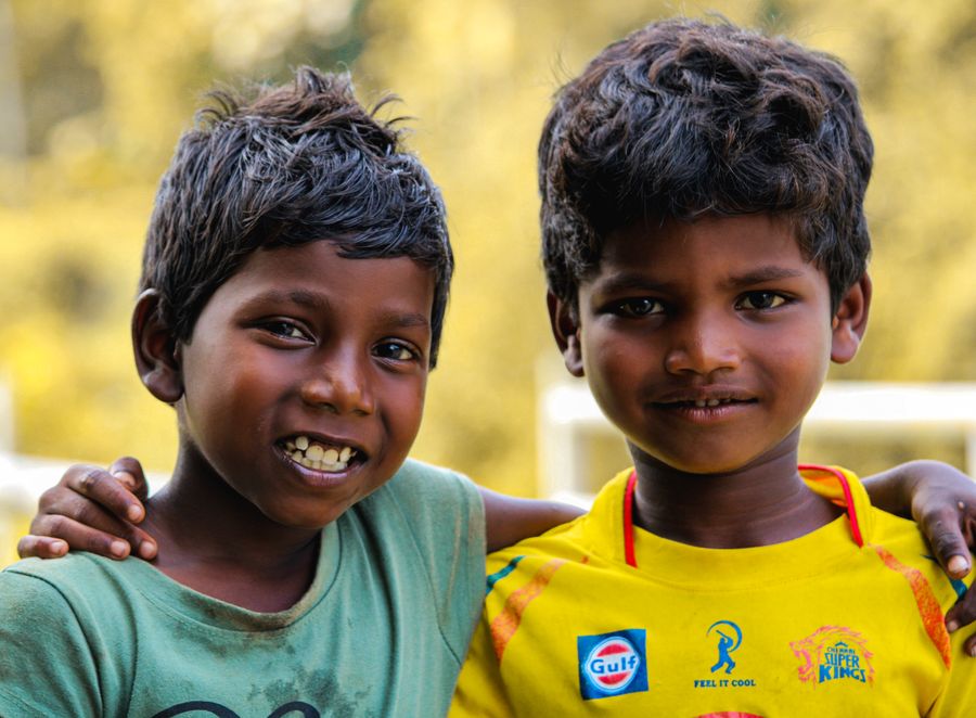 Two boys standing side by side outdoors